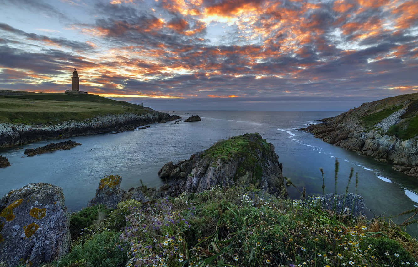 Tower Of Hercules Beneath The Cloudy Sunset Sky Background