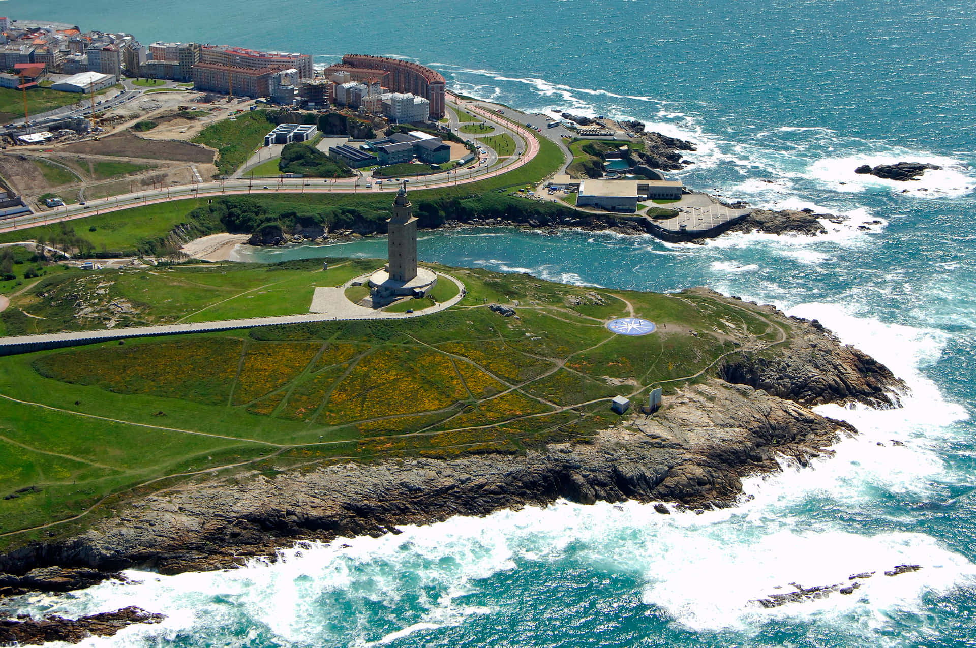 Tower Of Hercules Waves Crashing Against Shore Background