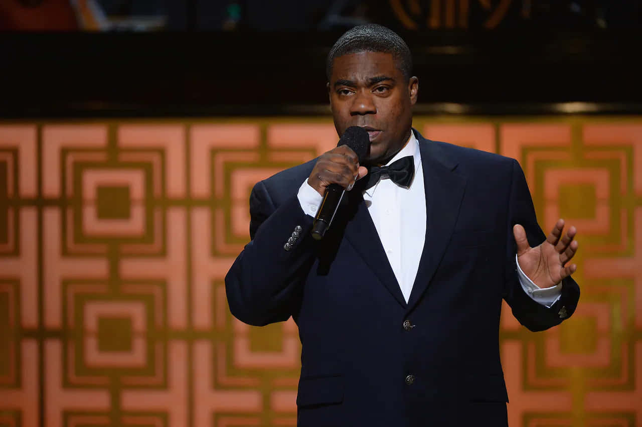 Tracy Morgan Smiling With A Microphone In Hand Background