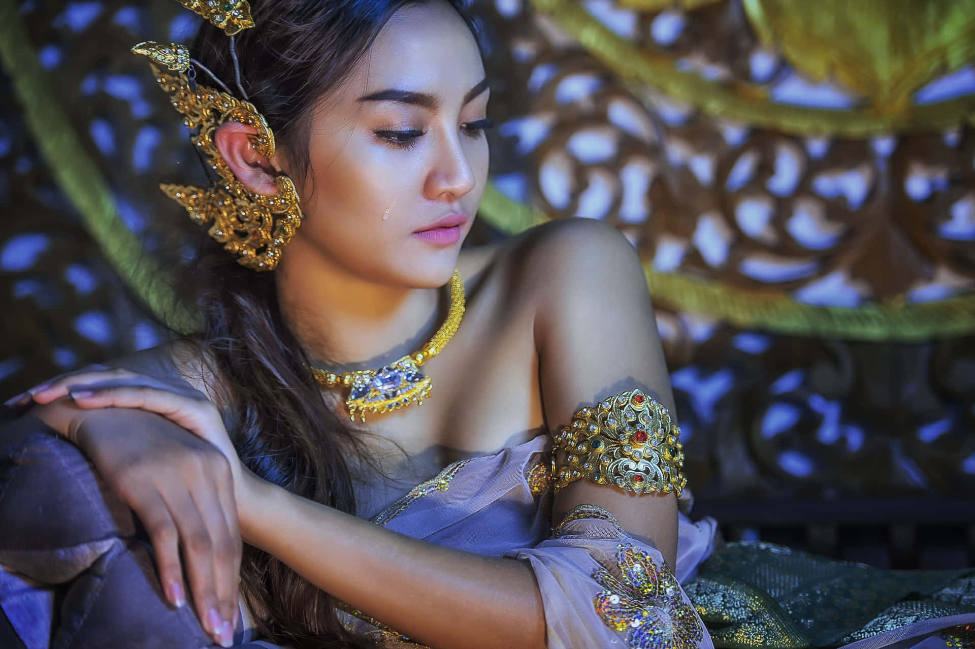 Traditional Thai Woman Adorned In Gold Accessories Background