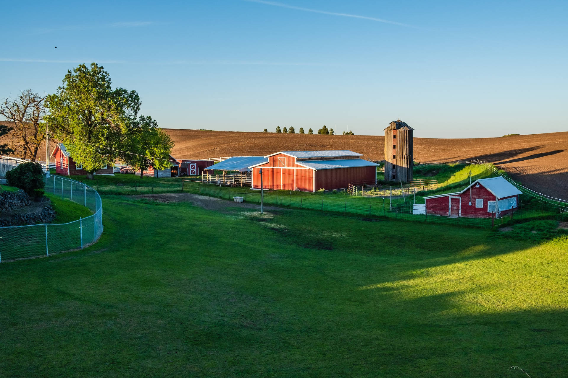 Tranquil Countryside Farm With Numerous Structures Background