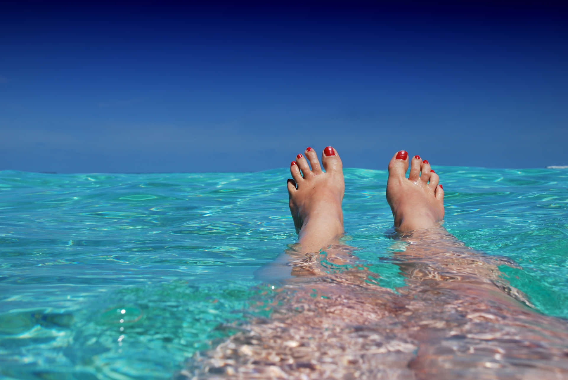 Tranquil Moment: Feet Soaking In Crystal Clear Water Background