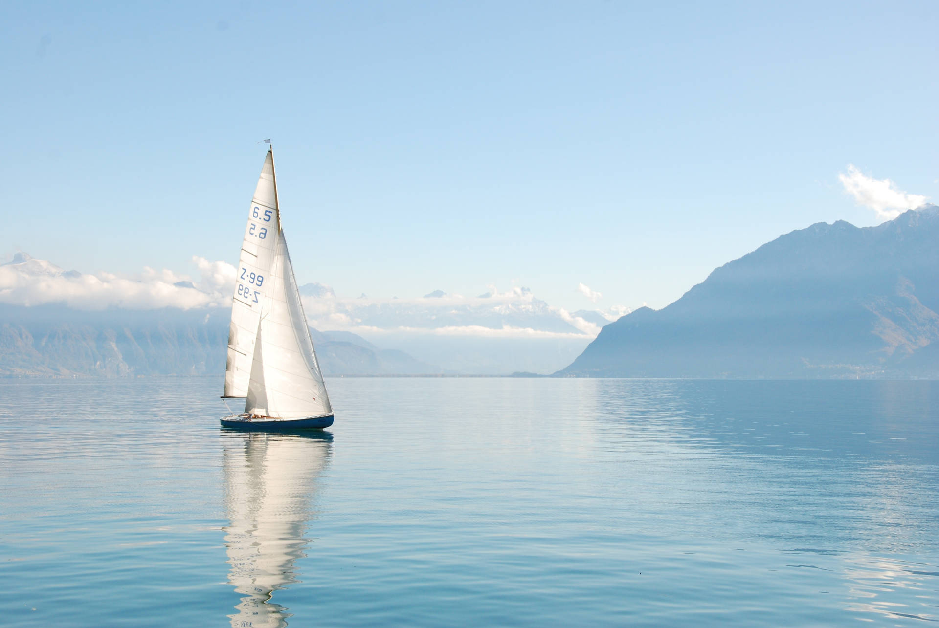 Tranquil Moment Of A Yacht Sailing In The Emerald Sea Background