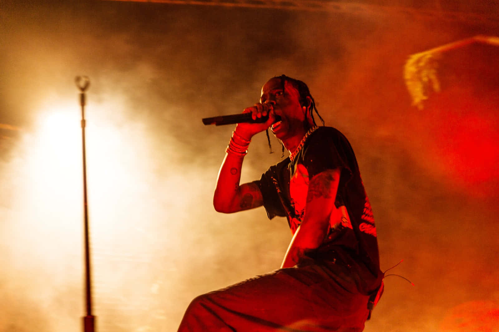 Travis Scott Pumping Up The Crowd In A Recent Concert Background