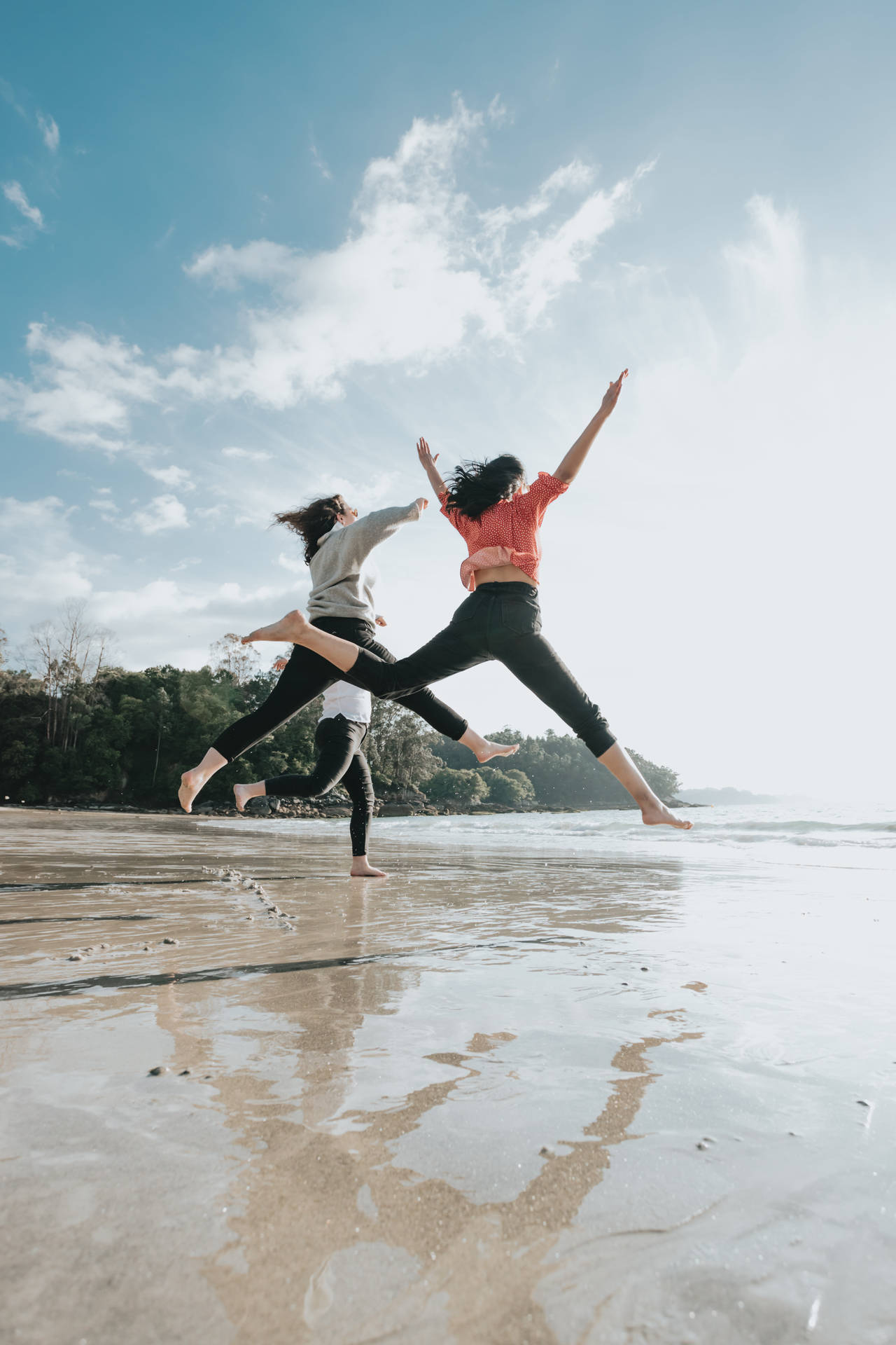 Trio Jumping On Shore Background