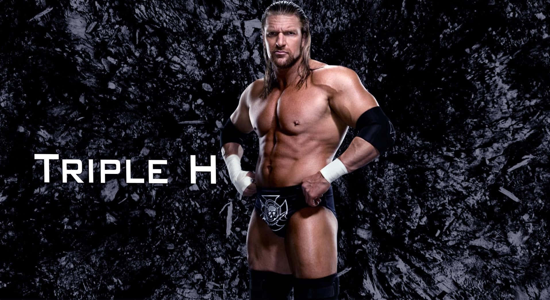 Triple H Posing Against Black Uneven Surface Background