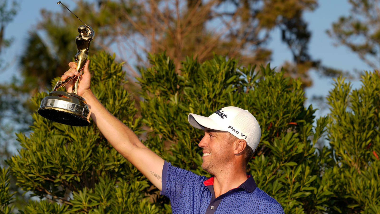 Triumph Personified: Justin Thomas Hoists Victory Trophy Background