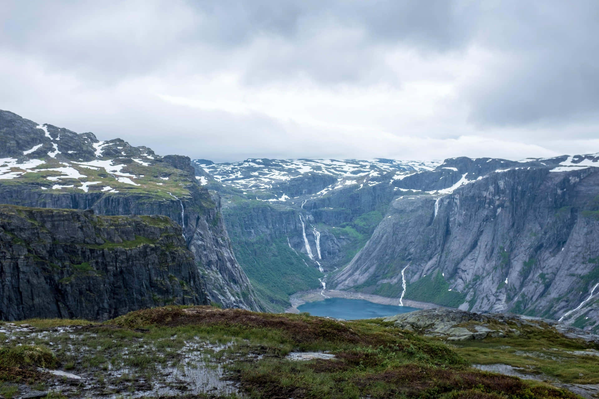 Trolltunga With Slight Snowy Peaks Background