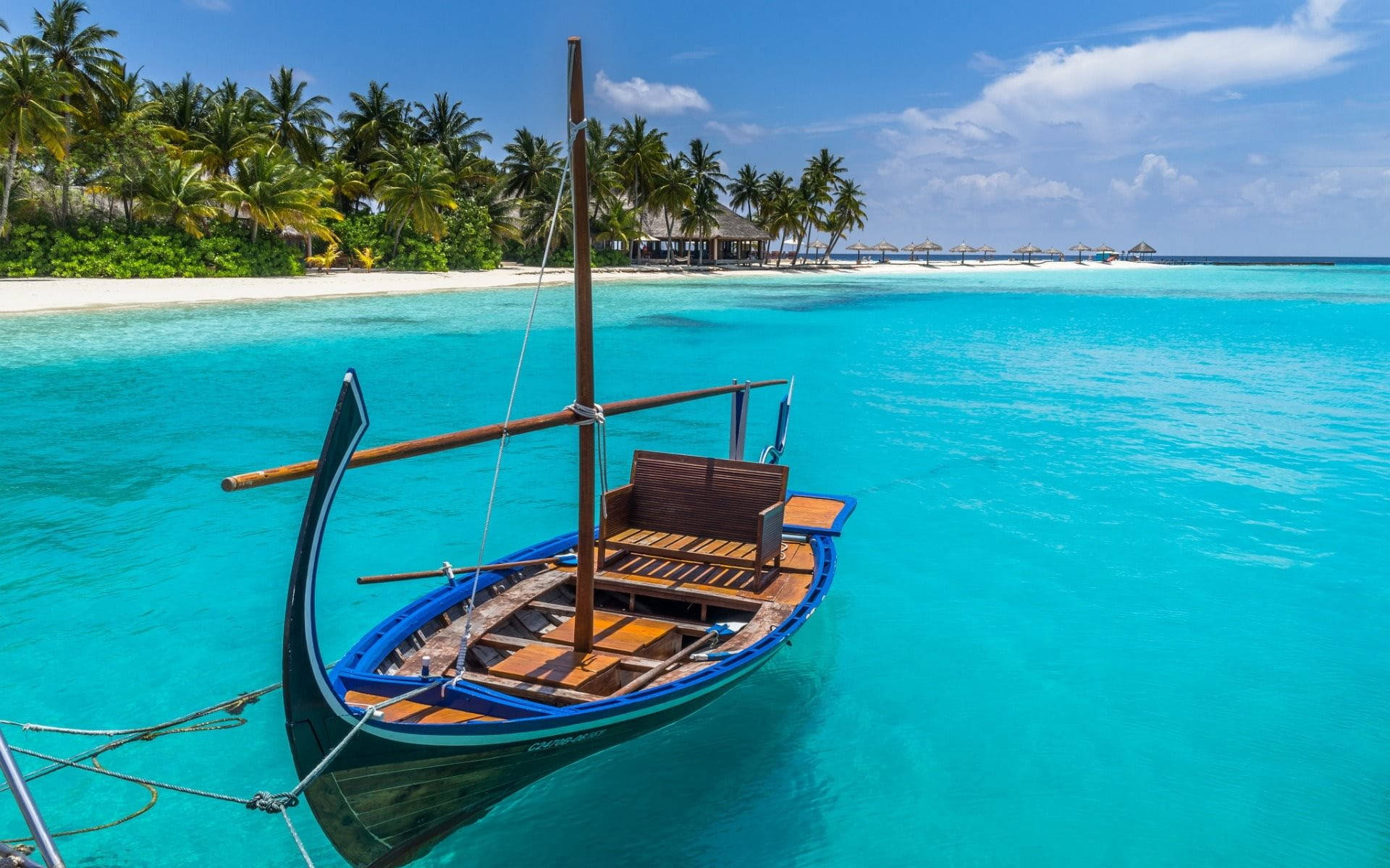 Tropical Serenity: A Boat On Azure Seas Background