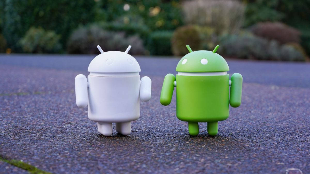 Two Android Toys Standing Next To Each Other Background