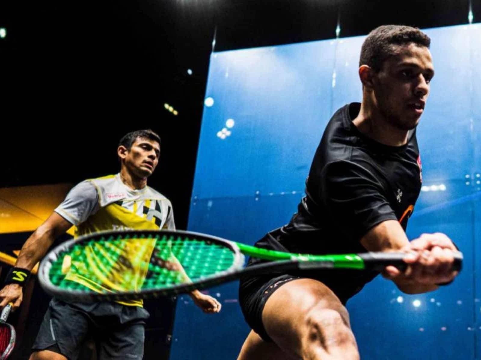 Two Athletic Boys Engaged In A Friendly Game Of Squash Background