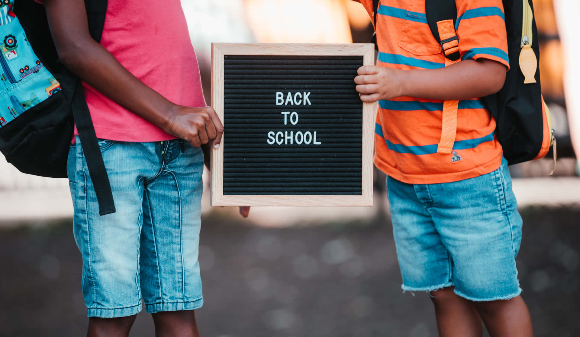 Two Children Holding A Back To School Sign