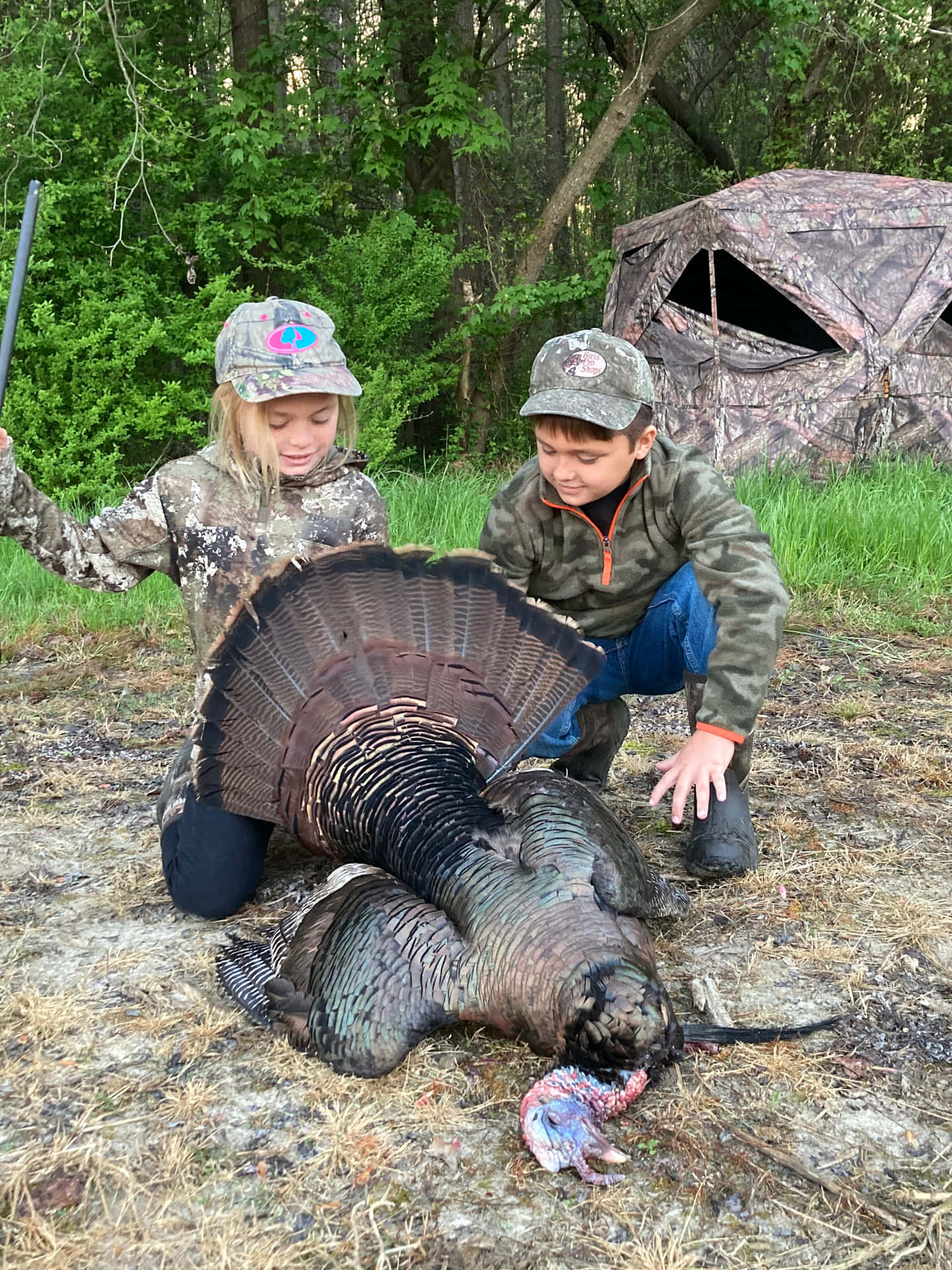 Two Children Posing With A Turkey Background