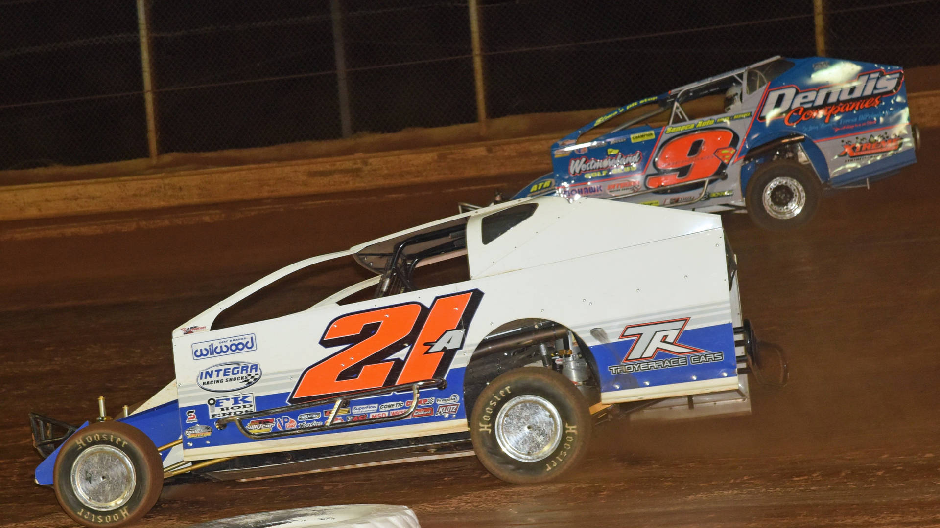 Two Dirt Cars Racing On A Dirt Track Background