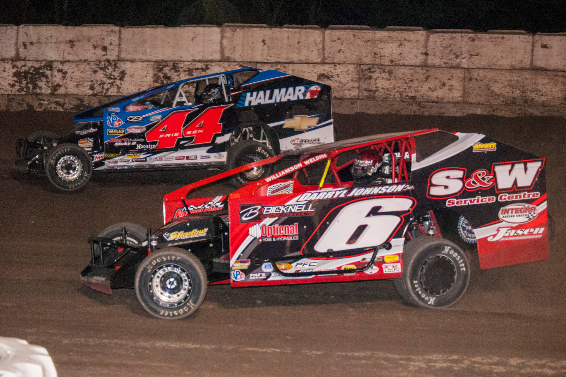 Two Dirt Race Cars Racing On A Dirt Track Background