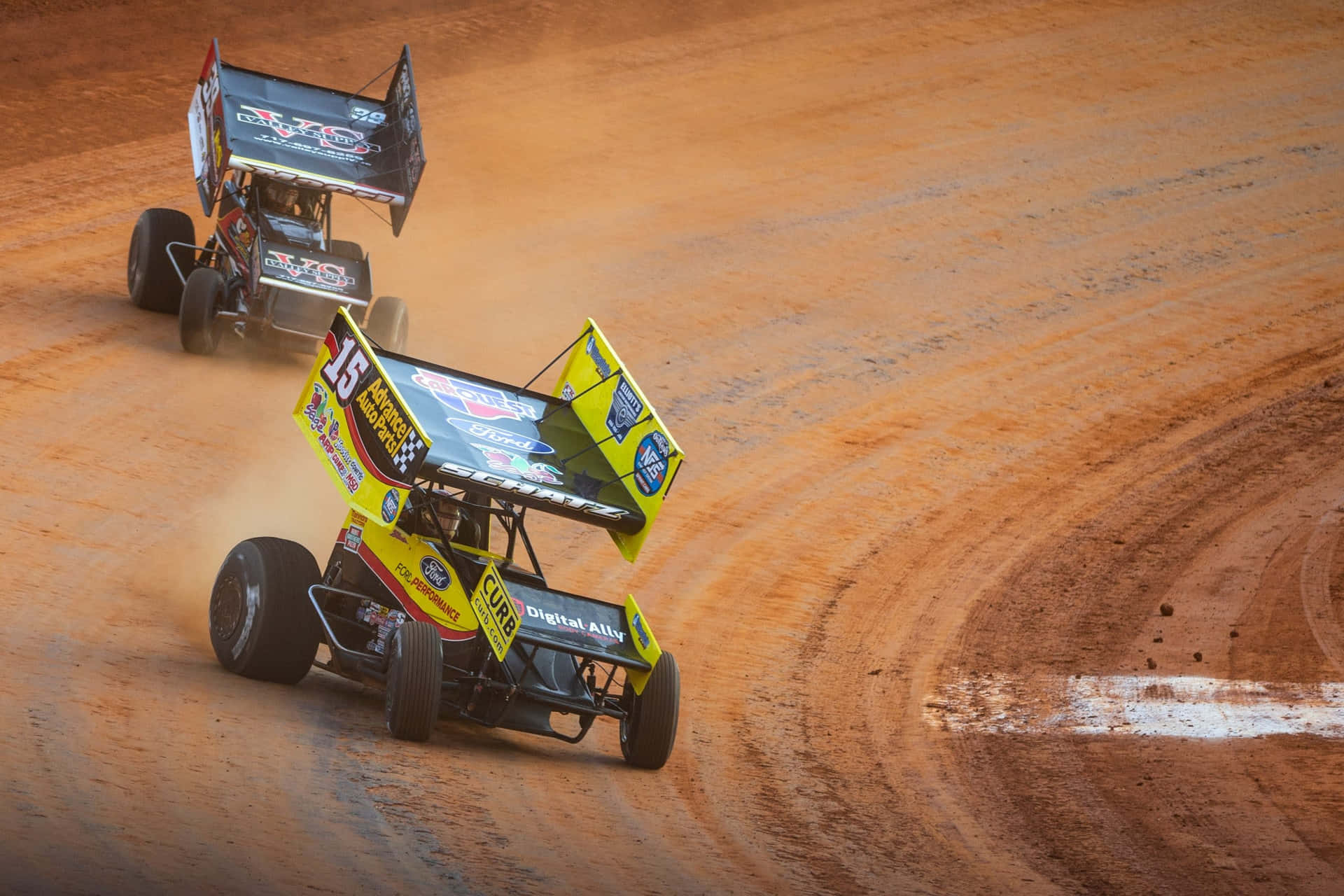 Two Dirt Track Racing Cars On A Dirt Track Background