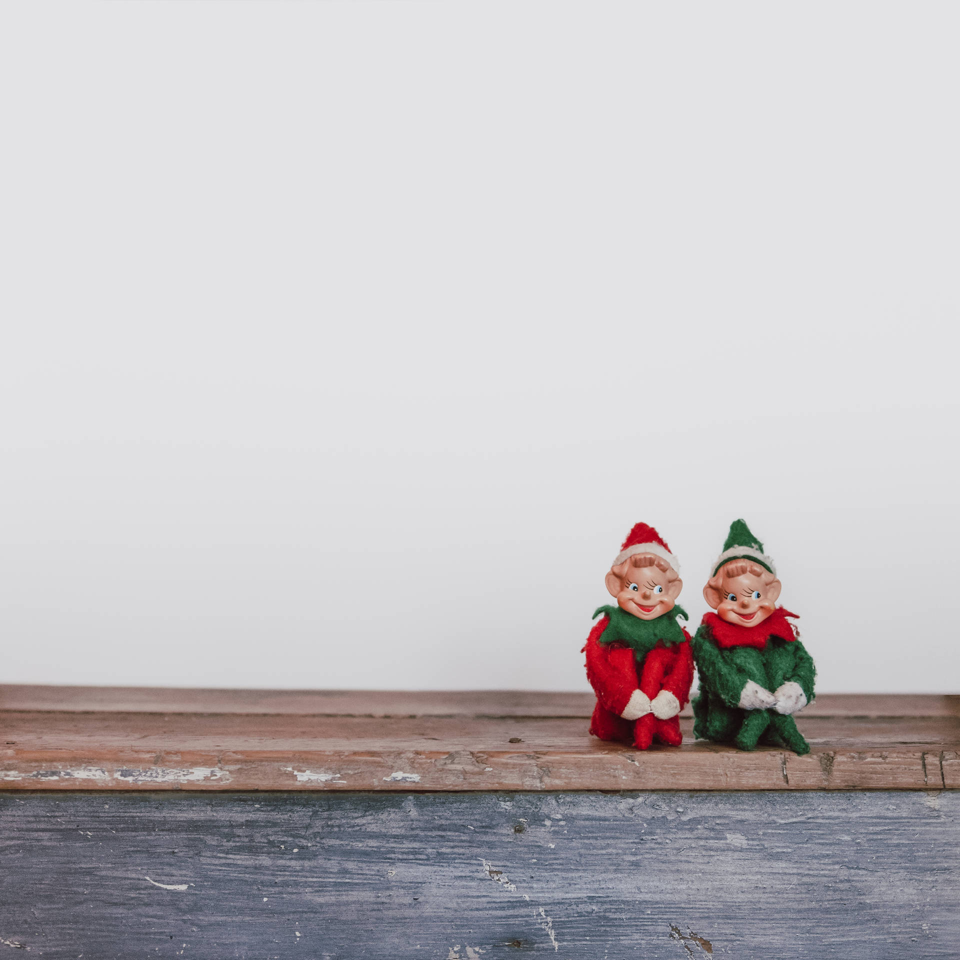 Two Elf Dummies Sitting On A Wooden Bench Background