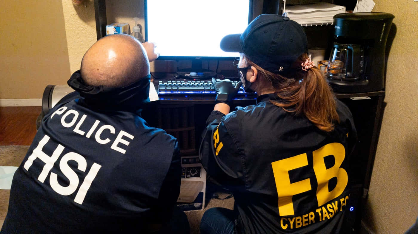 Two Fbi Agents Looking At A Computer Background