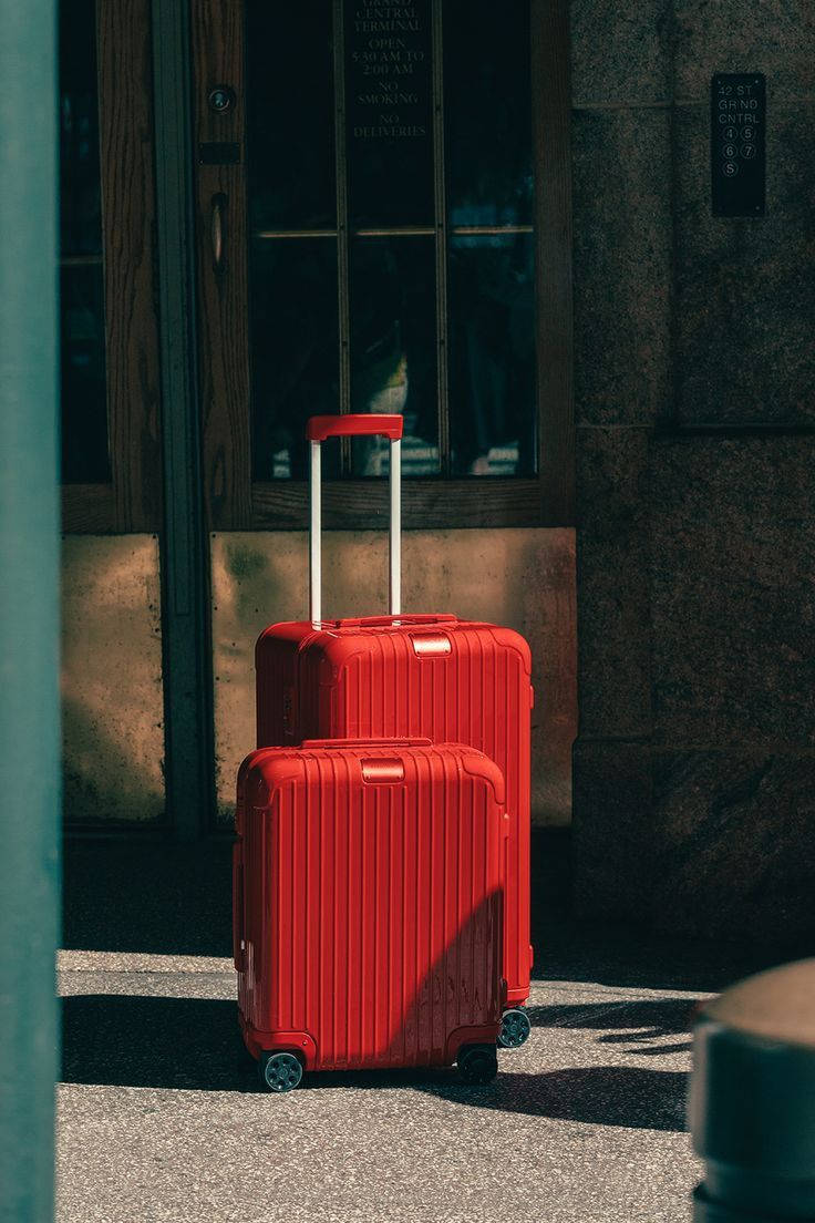 Two Flamingo Red Rimowa Suitcases Background