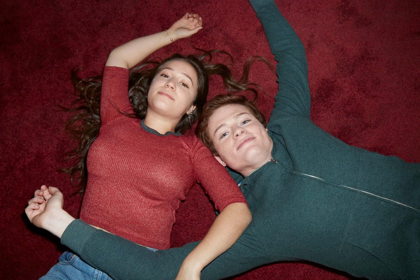 Two Friends Lying On Carpet Background