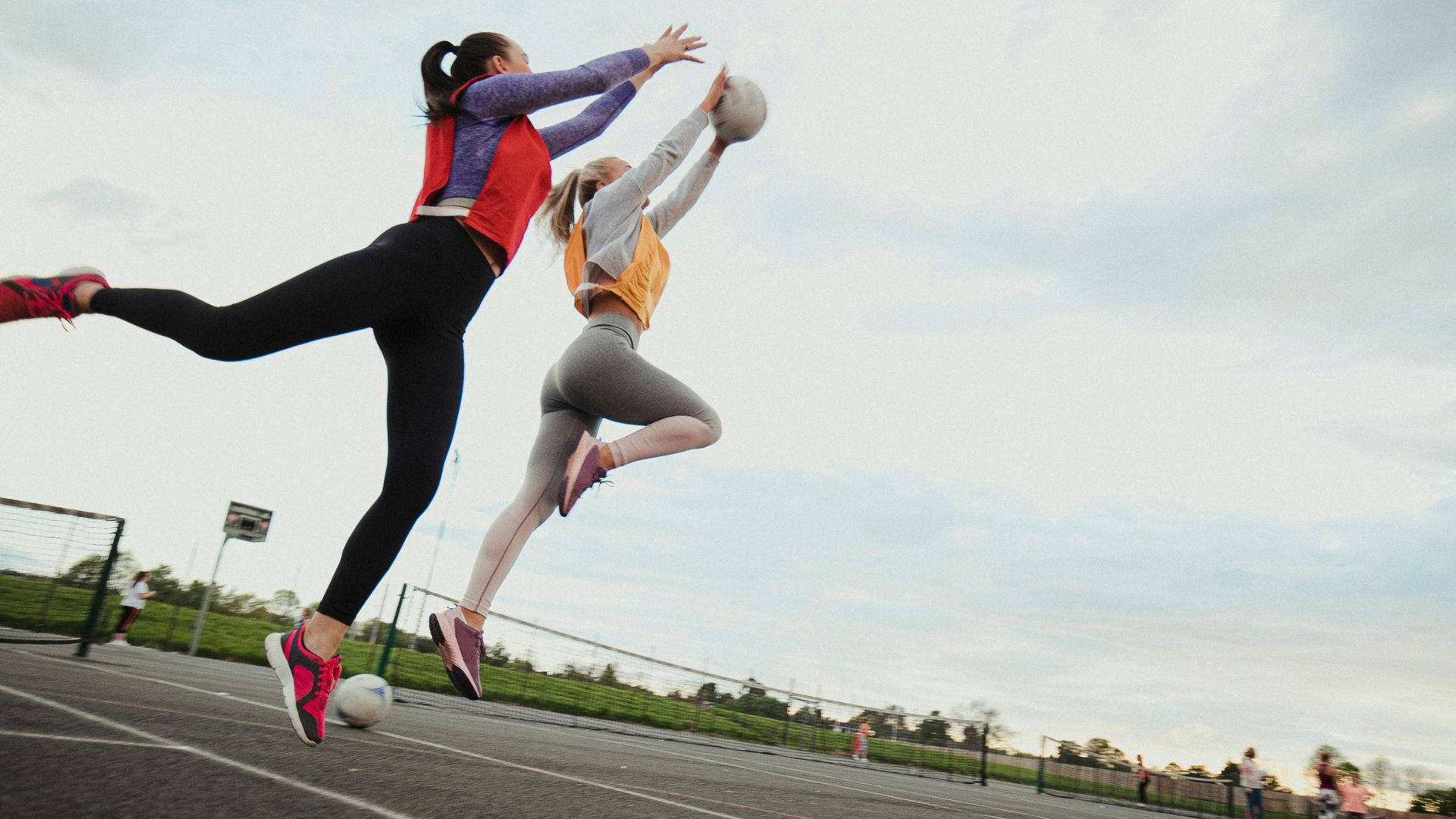 Two Girls Jump Race Catching Ball Netball