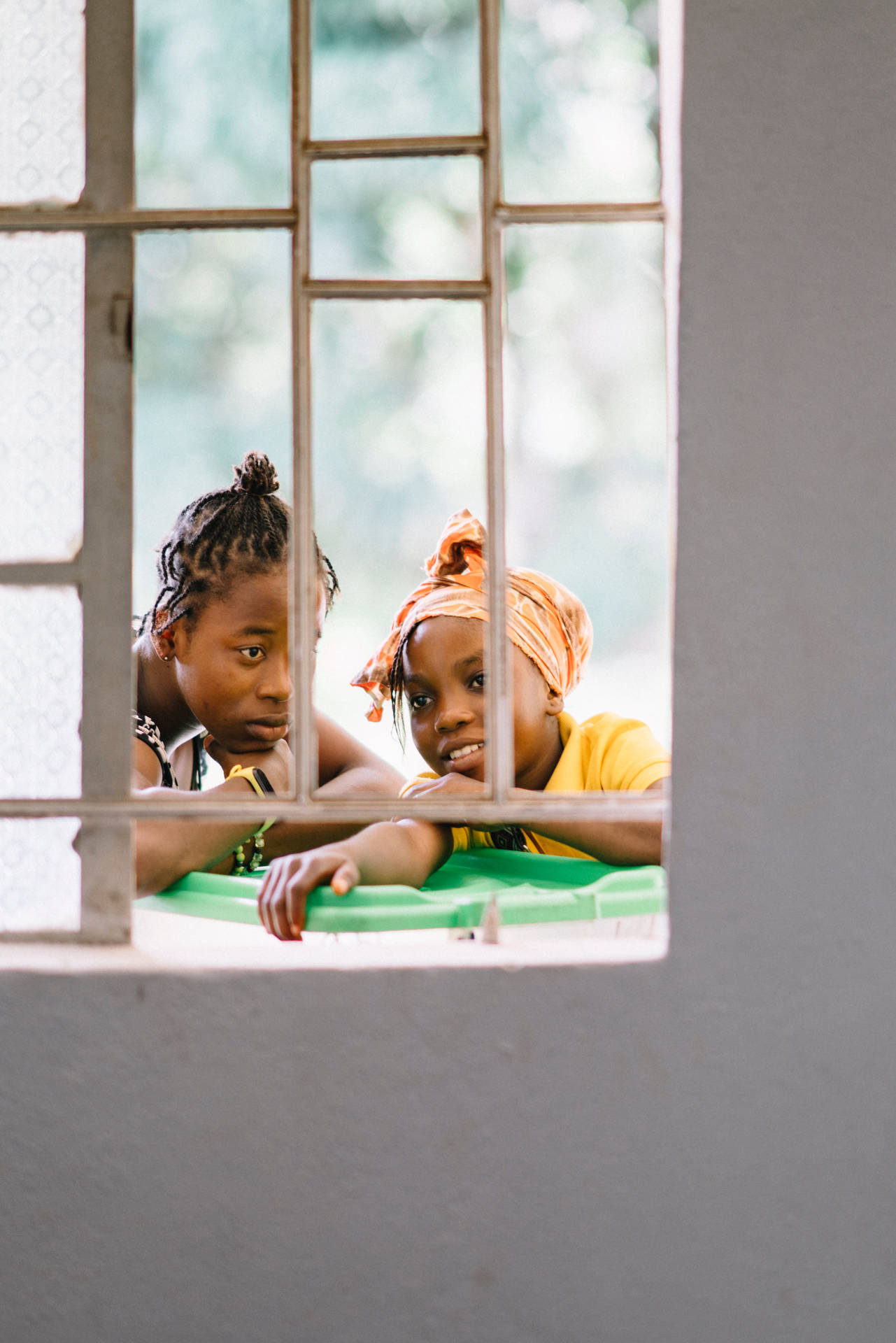 Two Girls Outside Window In Sierra Leone Background