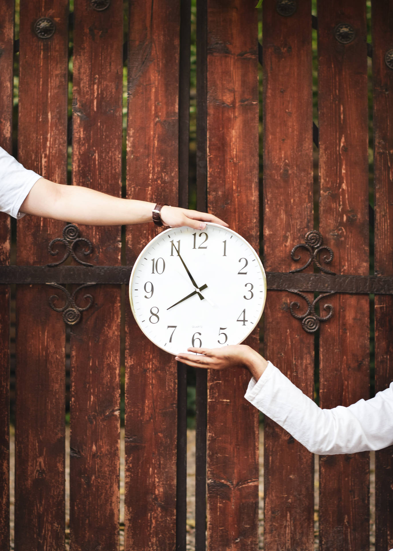 Two Hands Holding A Clock