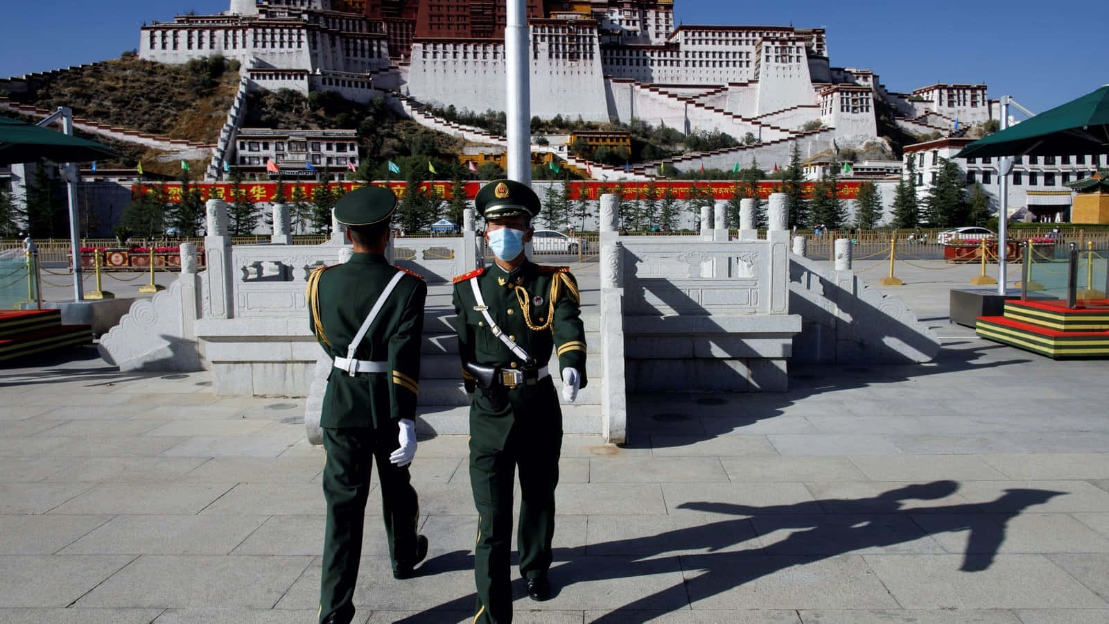 Two Men In Front Of Potala Palace In Lhasa