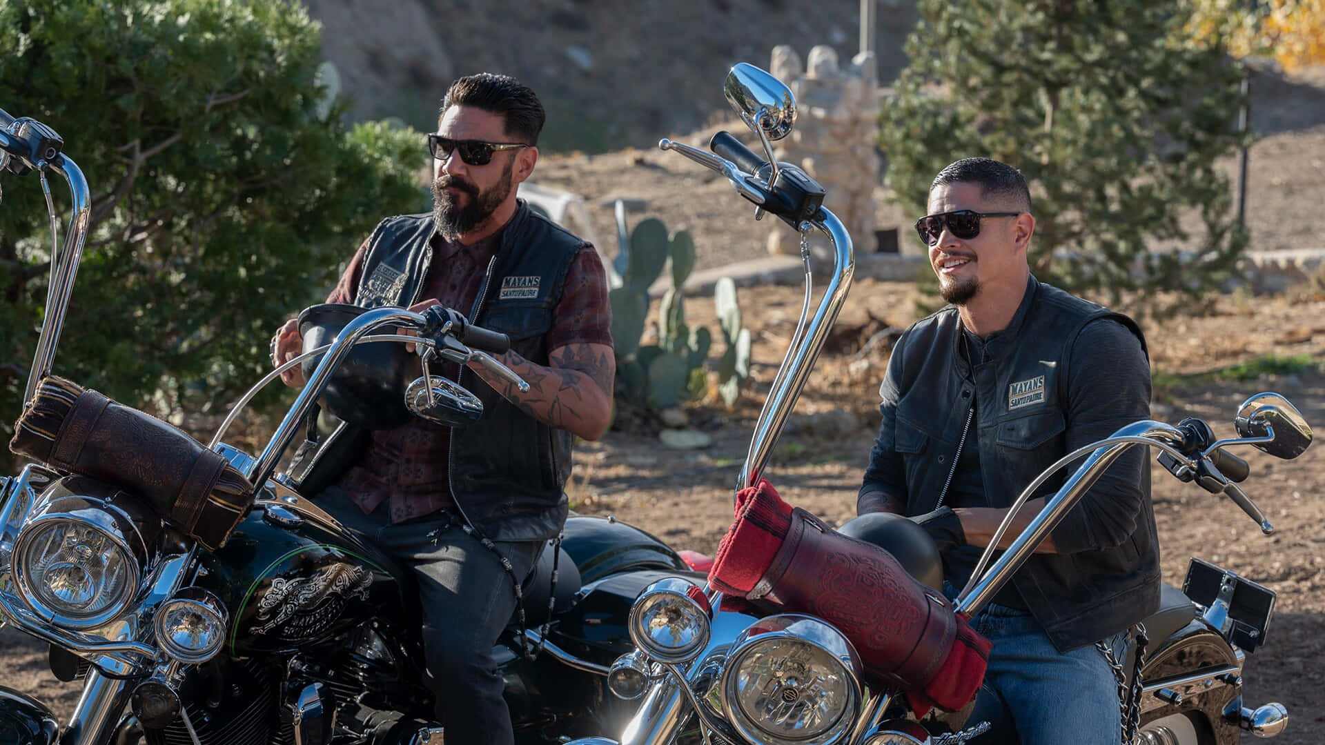 Two Men On Motorcycles Sitting On Dirt Background