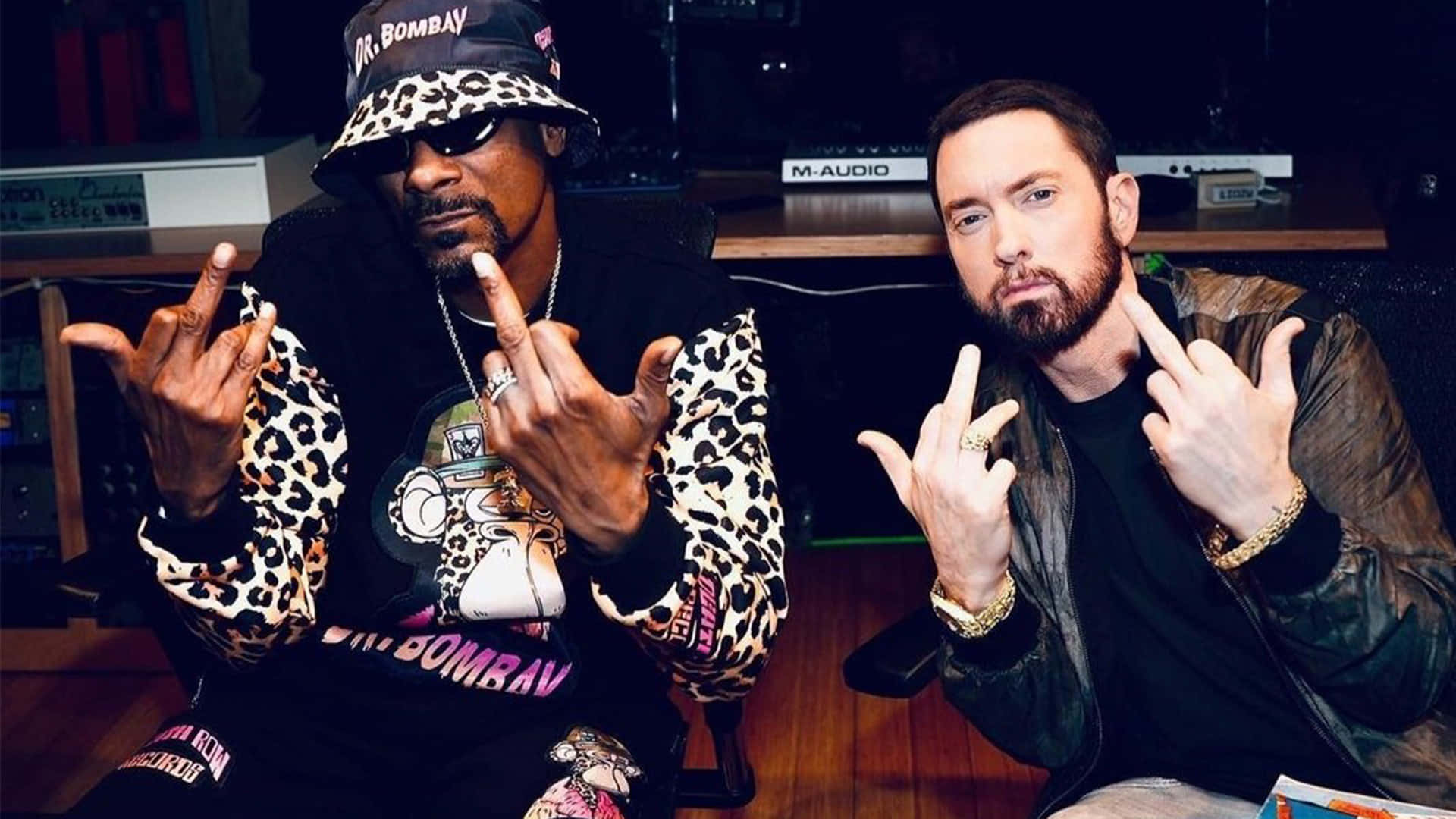 Two Men Sitting Next To Each Other In A Recording Studio Background