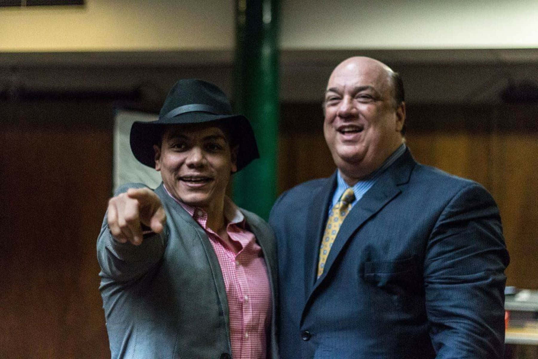 Two Men Smiling With One Pointing Background