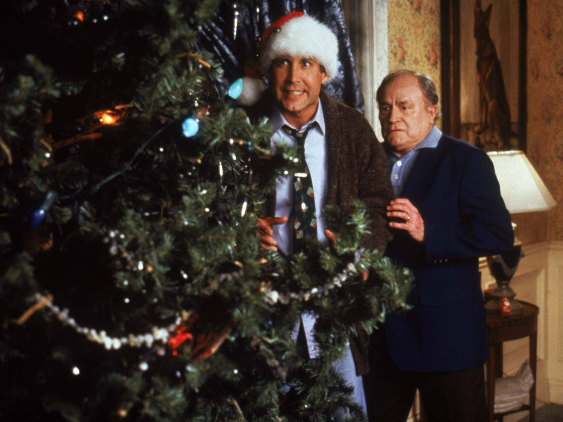 Two Men Standing Next To A Christmas Tree Background