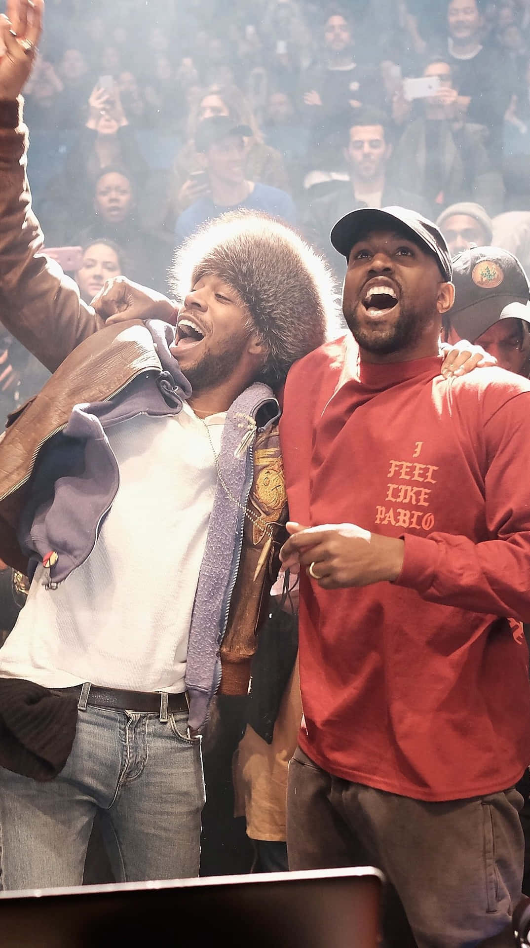 Two Men Standing Next To Each Other At A Concert