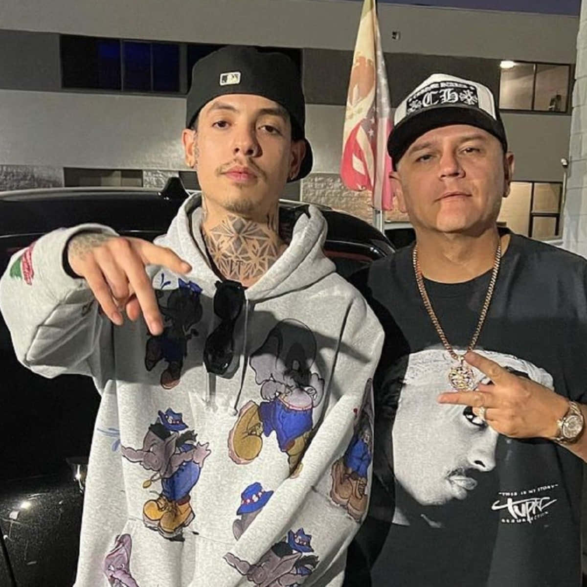Two Men Standing Next To Each Other With A Hoodie On Background