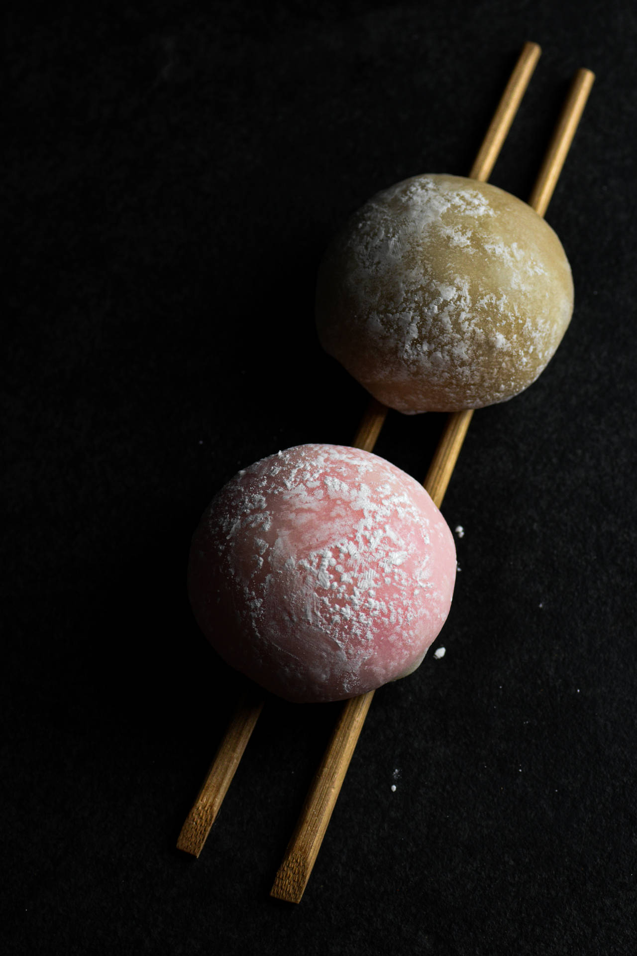 Two Mochi Pieces On Chopsticks Background
