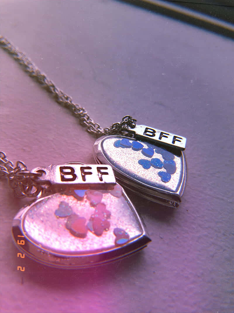 Two Necklaces With The Words Bff And Bff Background