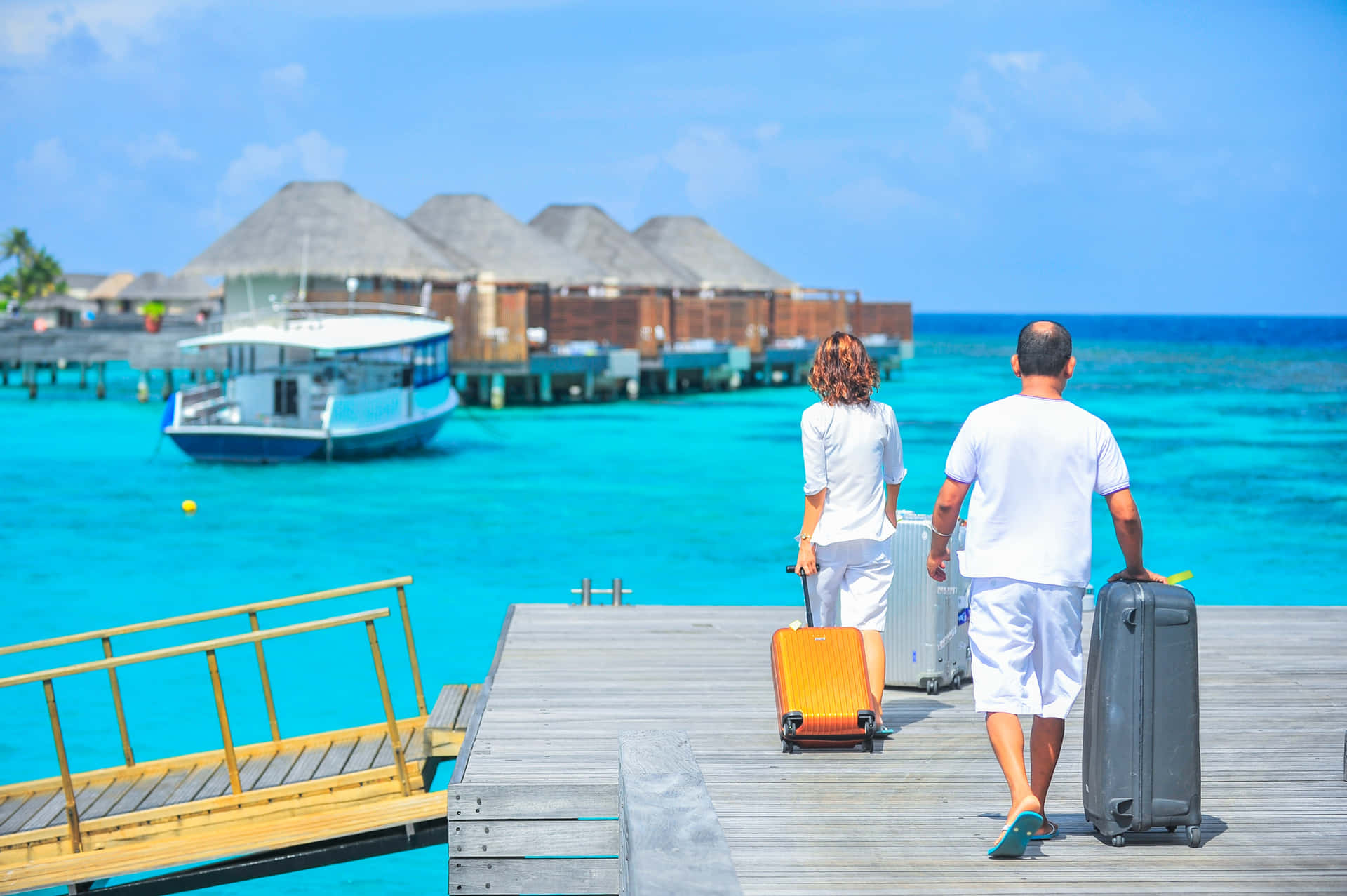 Two People Walking Down A Pier With Luggage Background