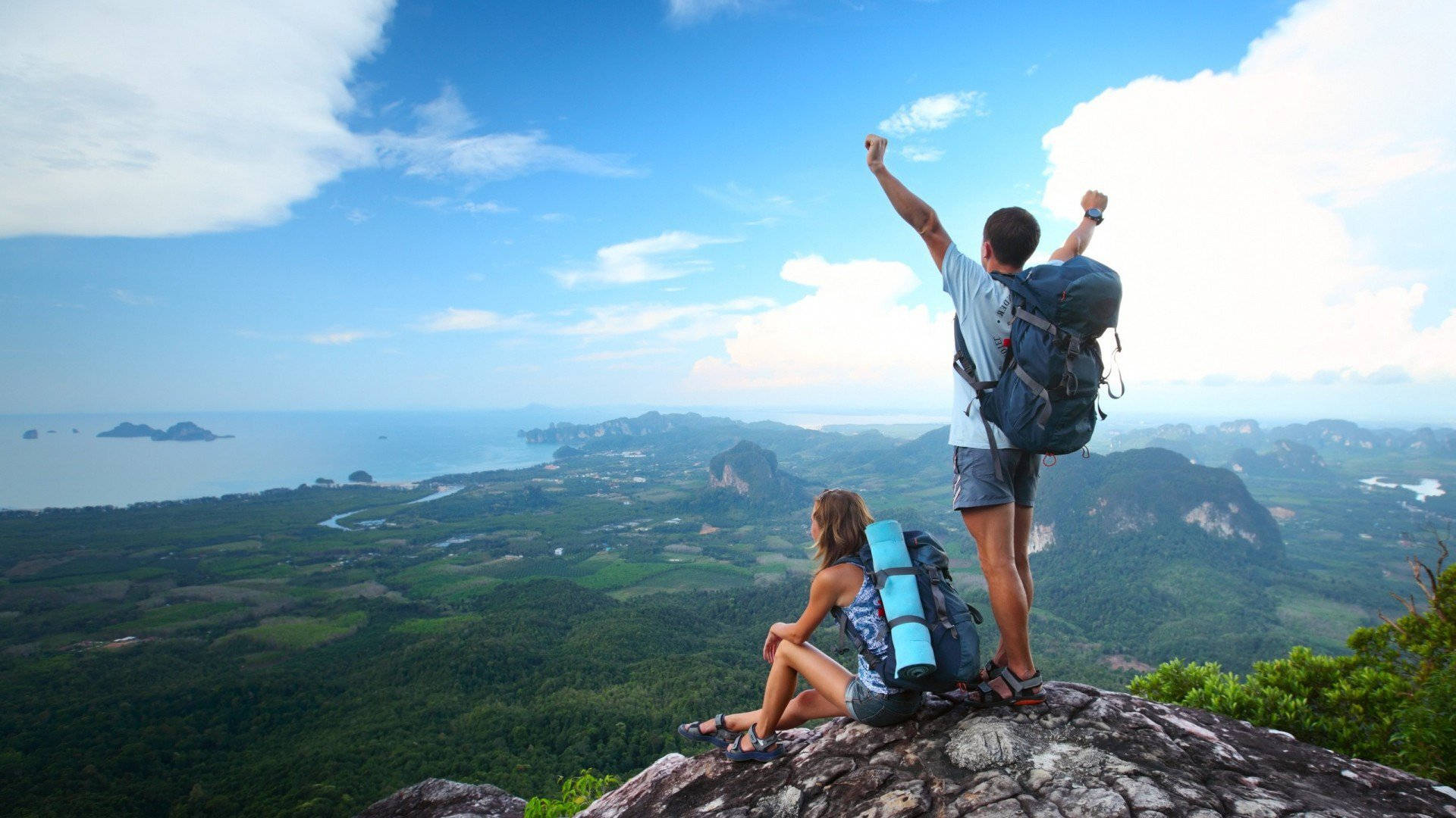 Two People With Backpacks On Top Of A Mountain Background