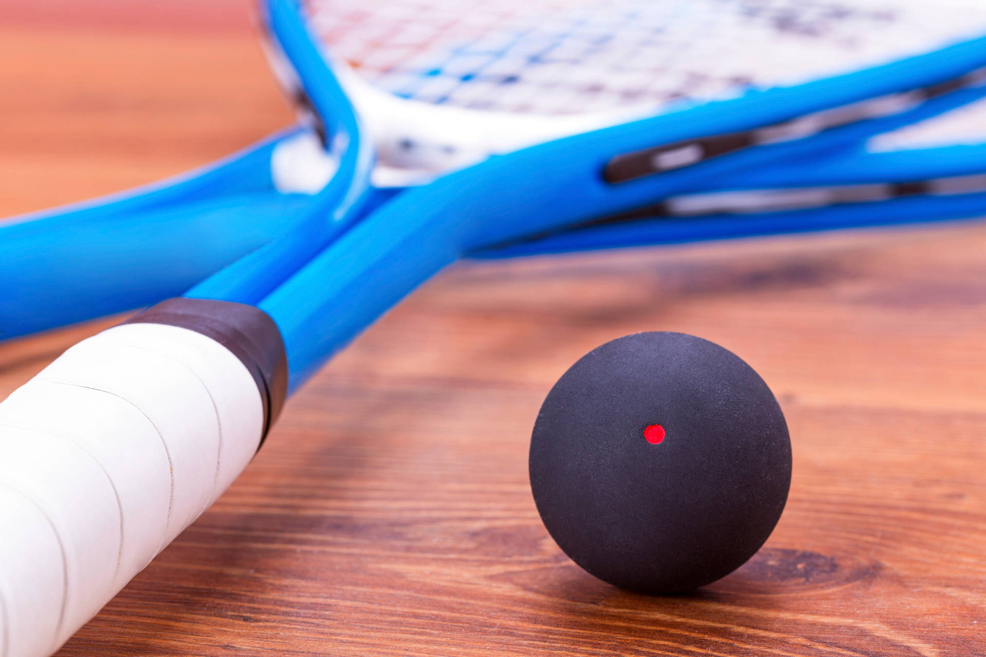 Two Racquetball Rackets And Ball On Court Background