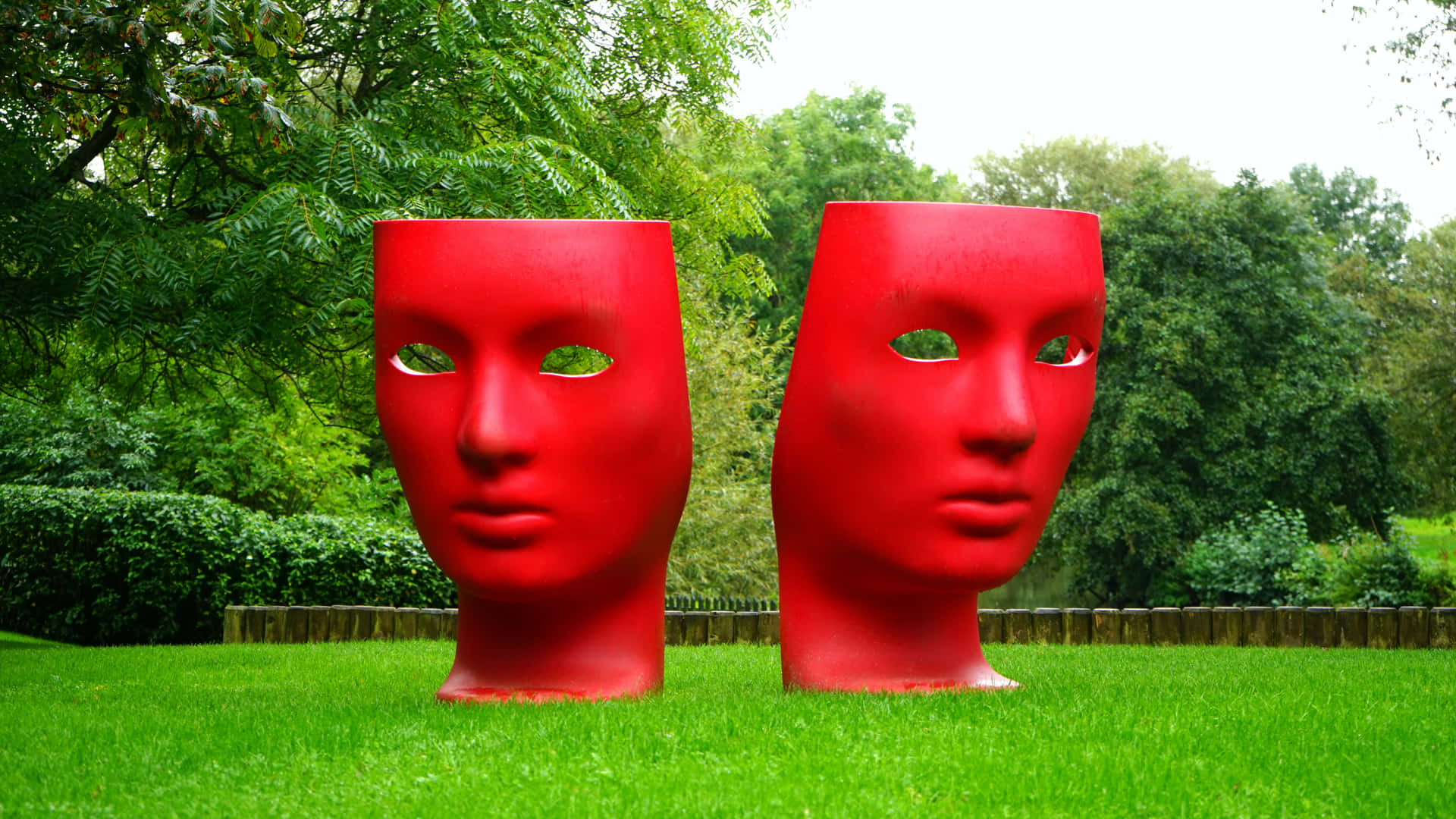 Two Red Sculptures In The Grass Background