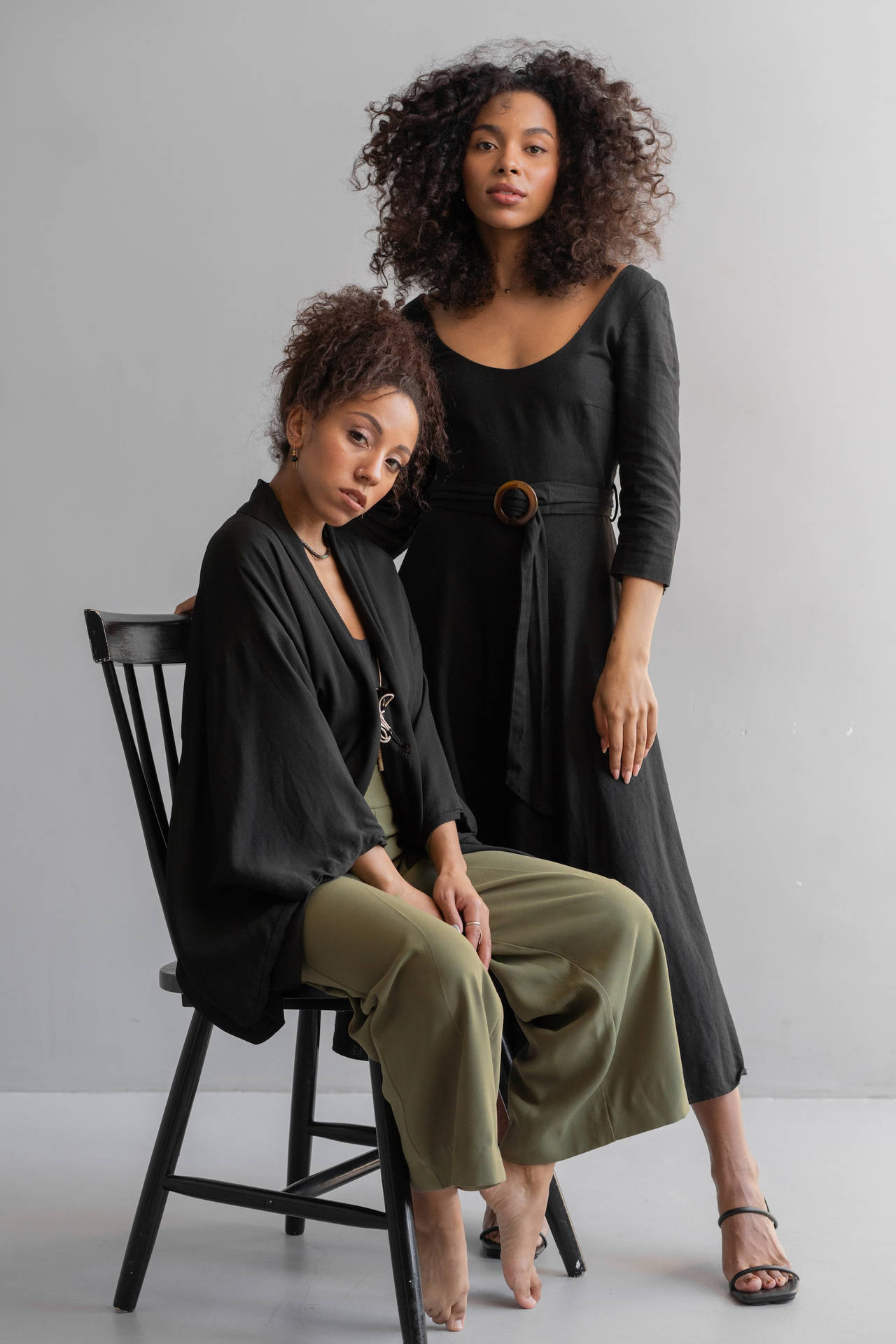 Two Sexy Black Women Modeling On A Chair Background