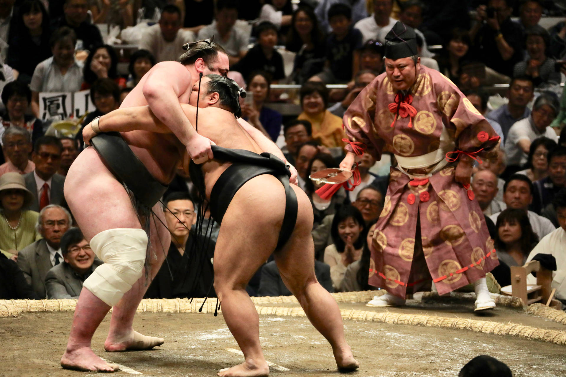 Two Sumo Wrestlers Clashing In An Epic Showdown Background