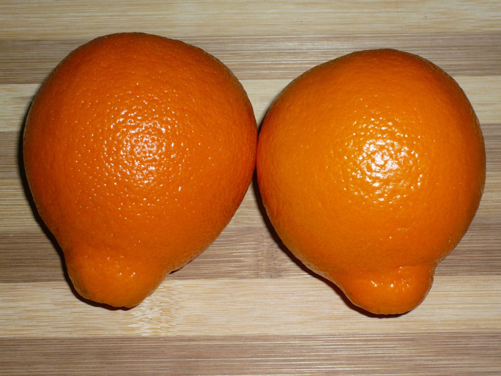 Two Tangelo Fruits On Chopping Board Background