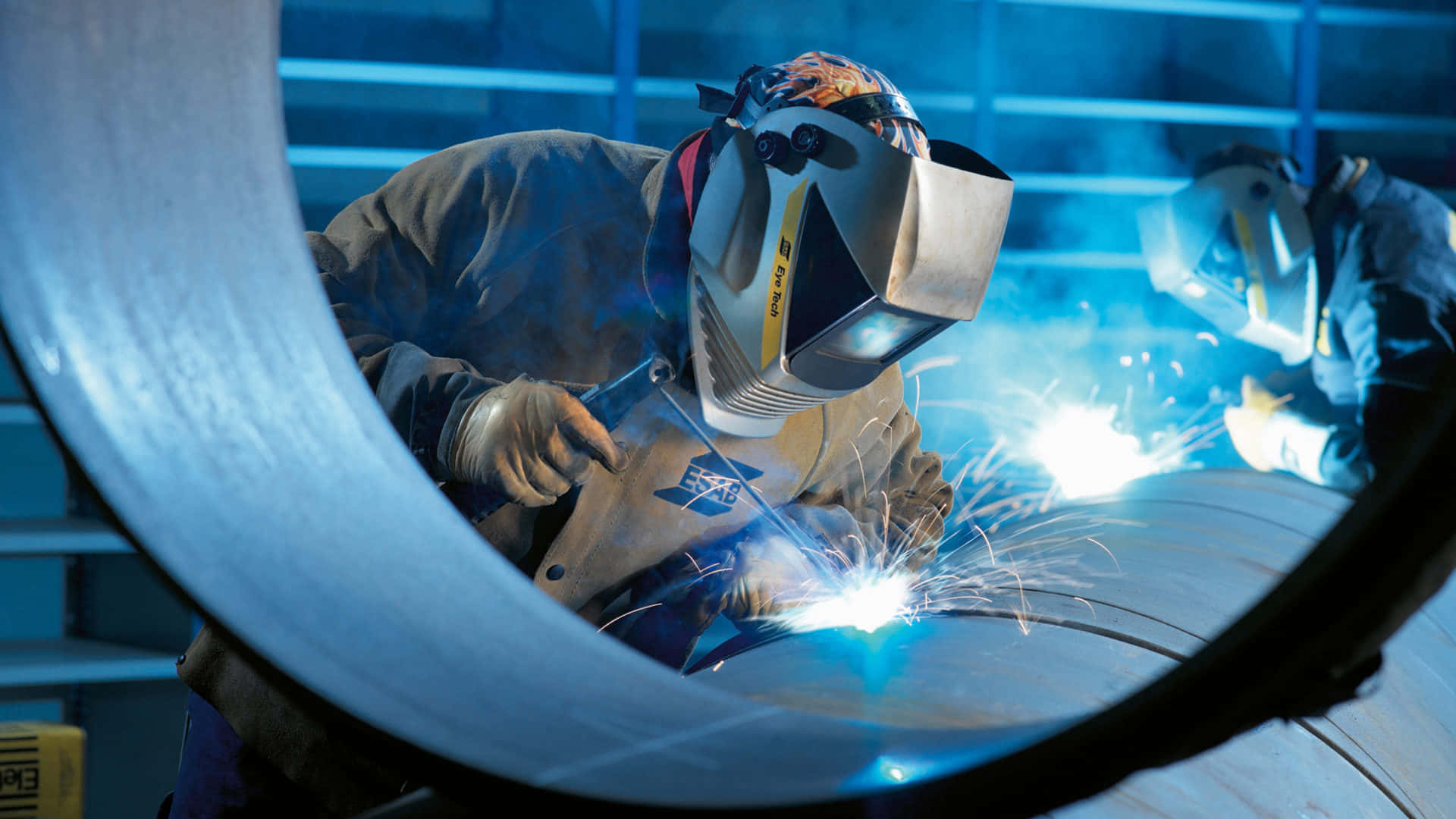 Two Welders Working On A Pipe Background