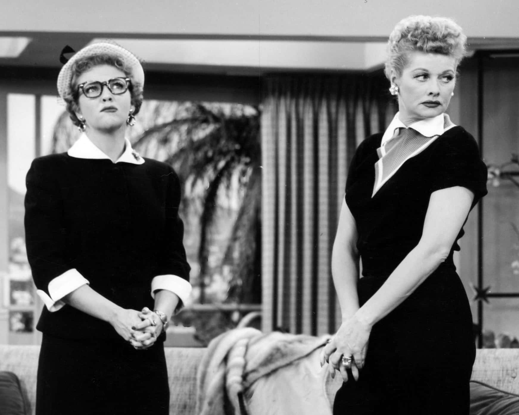 Two Women In Black And White Standing Next To Each Other