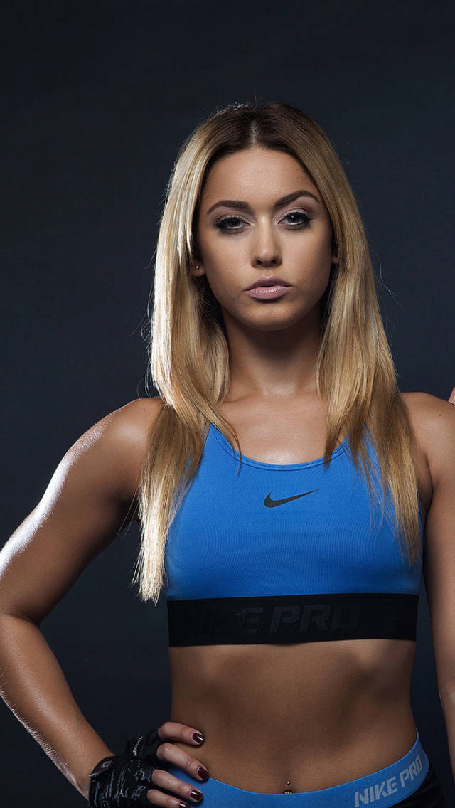 Two Women In Blue Sports Bras Posing For A Photo Background