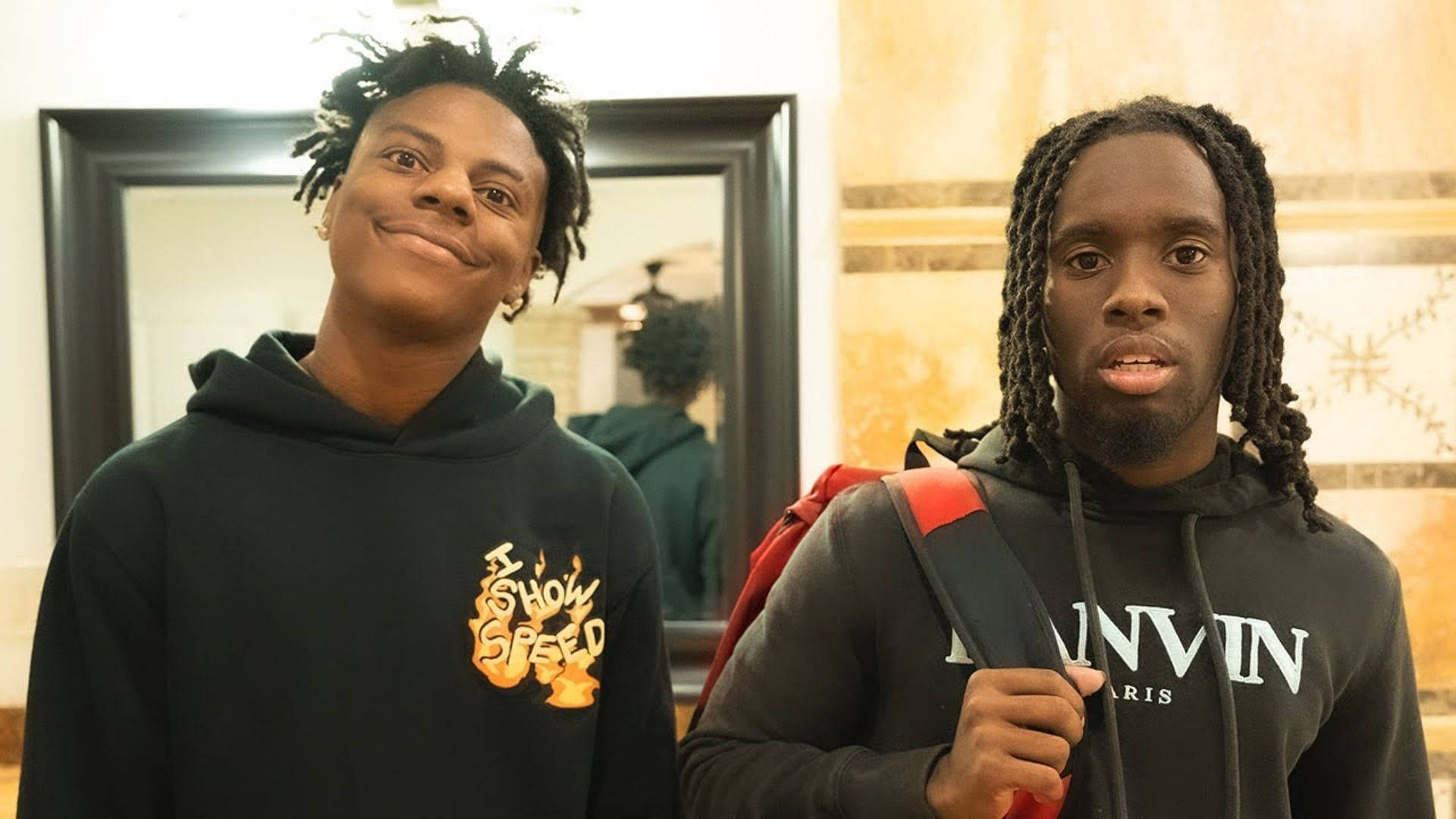 Two Young Men Standing In A Bathroom With Backpacks Background