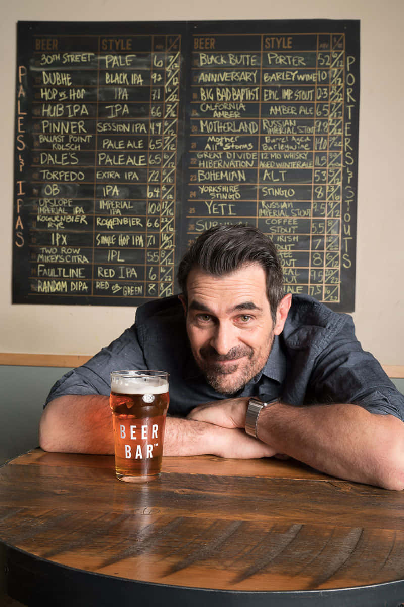 Ty Burrell Striking A Pose In A Stylish Suit Background