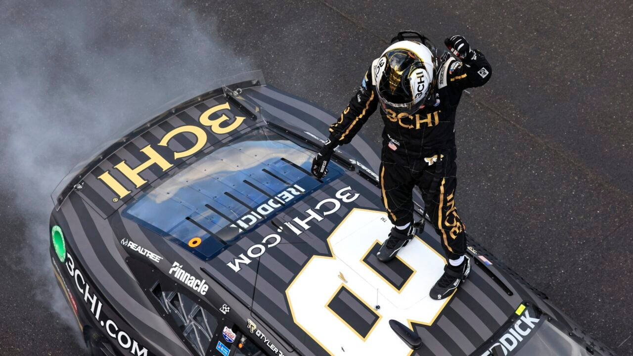 Tyler Reddick On Top Of Car Background