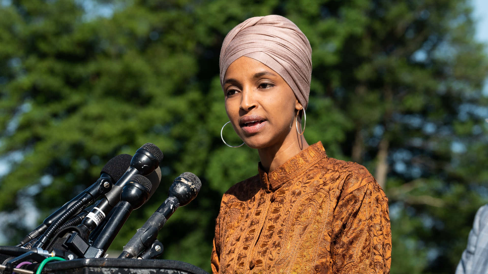 U.s. Representative Ilhan Omar Exudes Elegance And Confidence Background